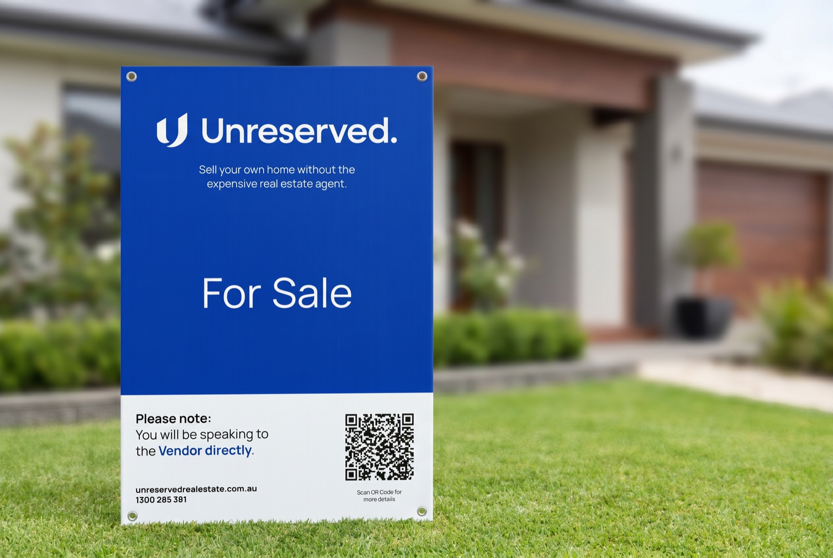 Unreserved 'For Sale' board planted on the front lawn of a contemporary coastal home
