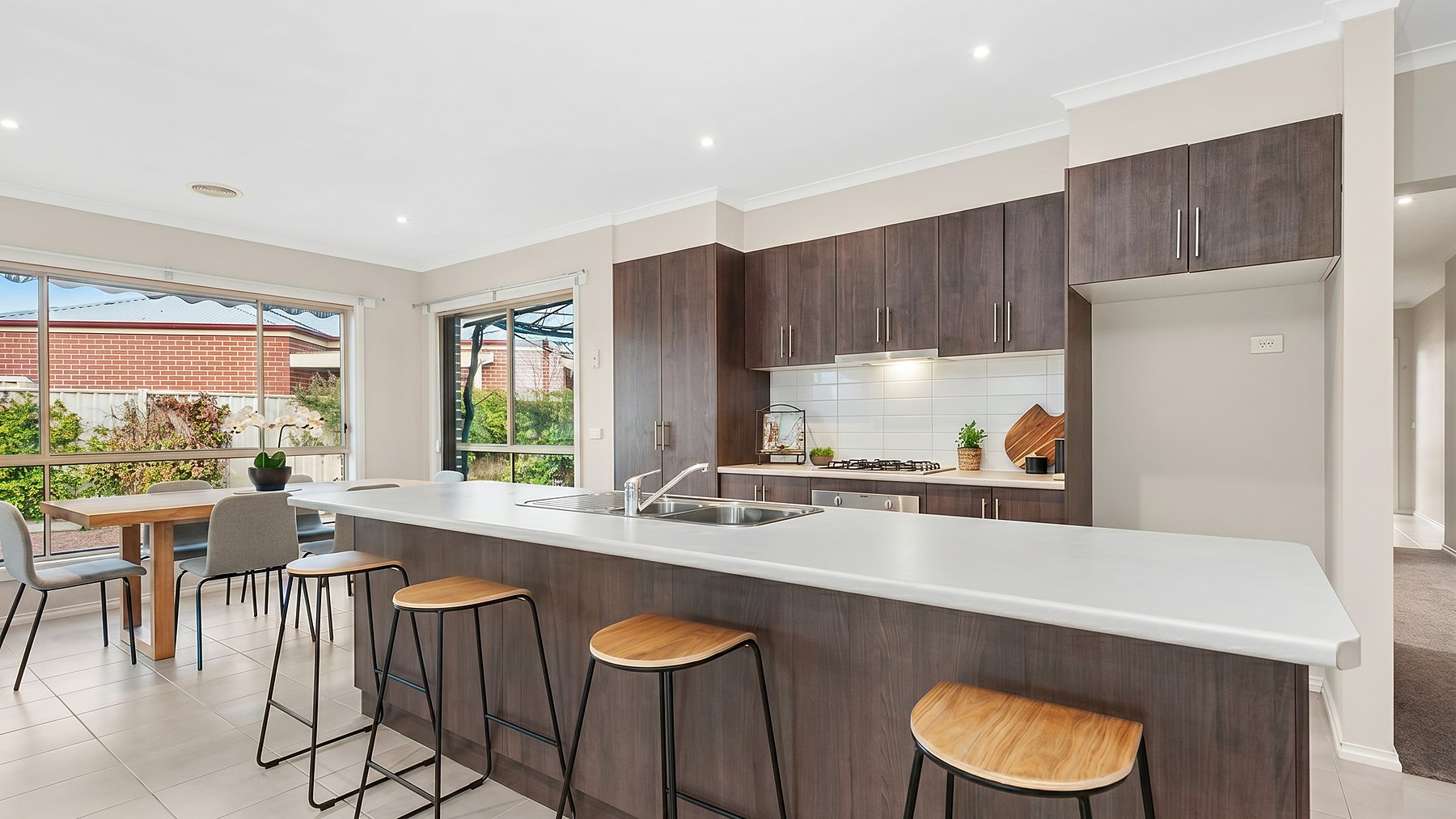 Kitchen and meals area of 11 Jess Way, Sebastopol, with a stone island bench and timber stools